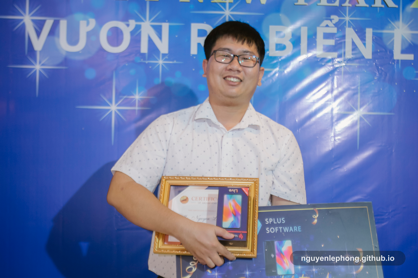Nguyen Le Phong holds a Best Rookie award at a company recognition event, with the framed certificate and prize board in view.