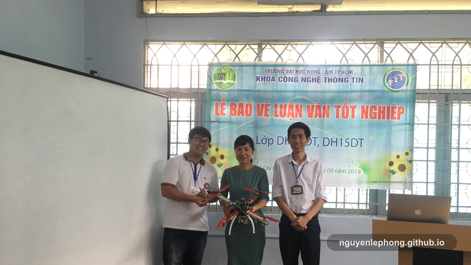 Nguyen Le Phong, a faculty reviewer, and a teammate stand with a drone prototype after a university thesis review session in Ho Chi Minh City.