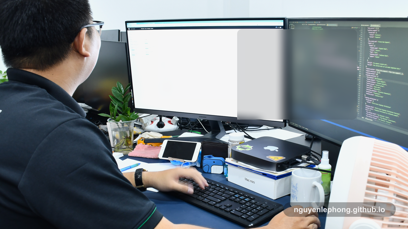 Nguyen Le Phong làm việc trước bàn hai màn hình, xem lại code và chi tiết triển khai trong một văn phòng chung.