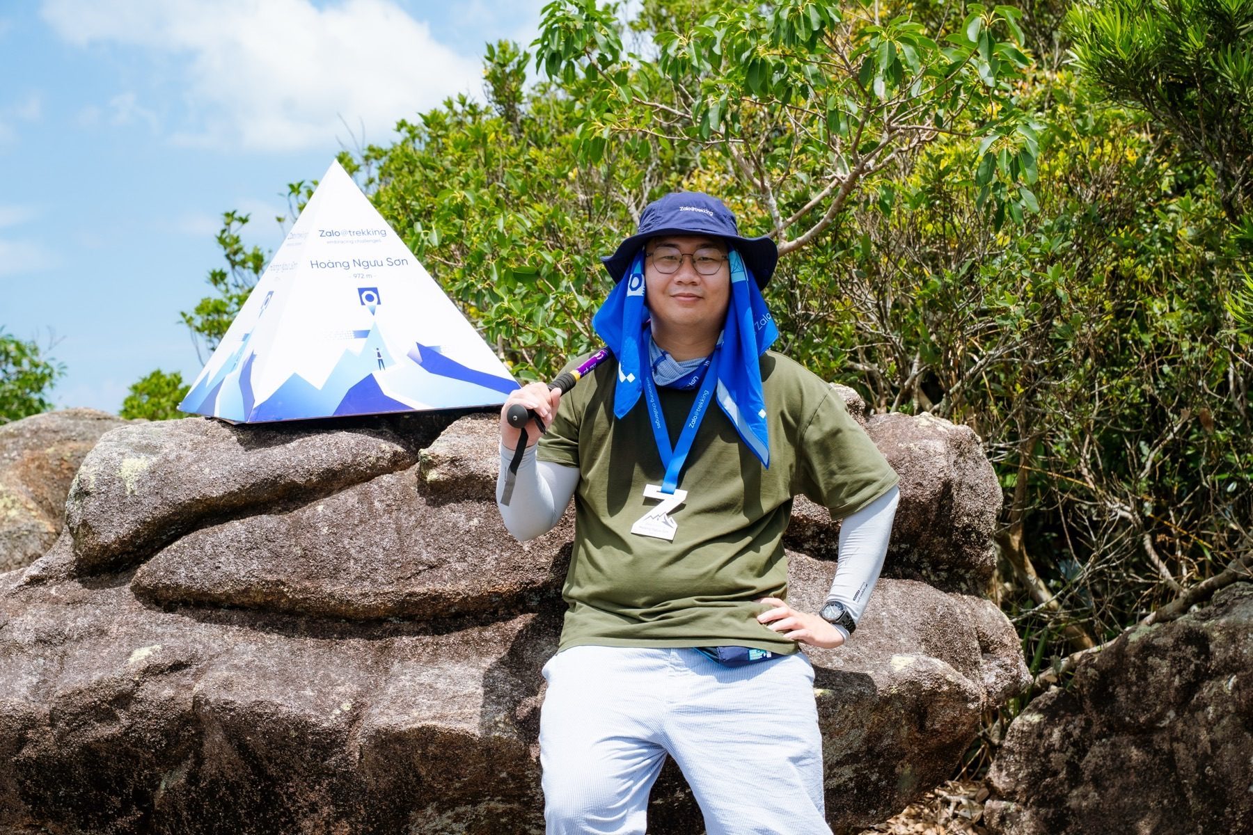 Nguyen Le Phong standing beside the Hoang Nguu Son trekking marker