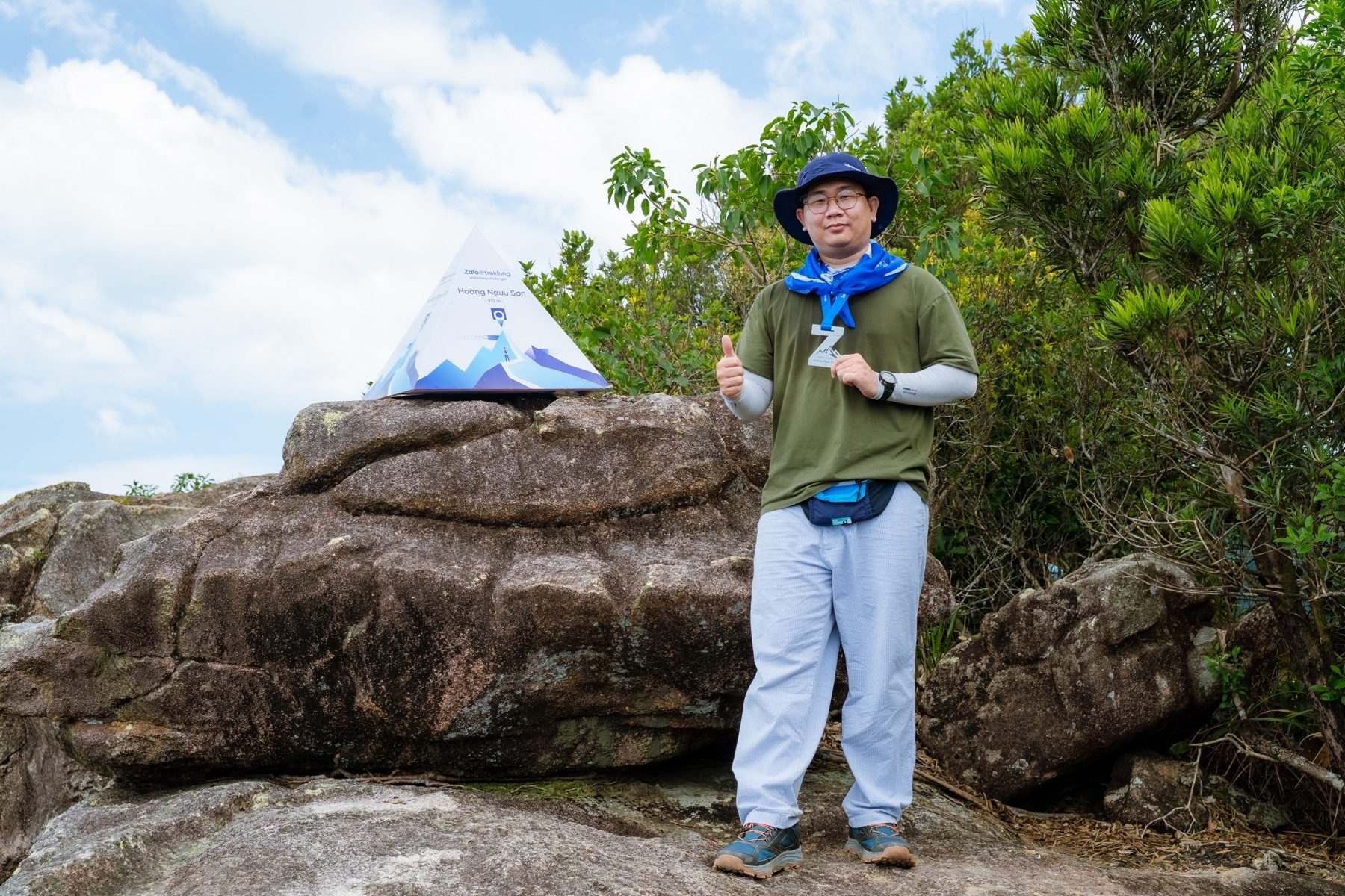 Nguyen Le Phong standing on the trekking trail with the Hoang Nguu Son marker