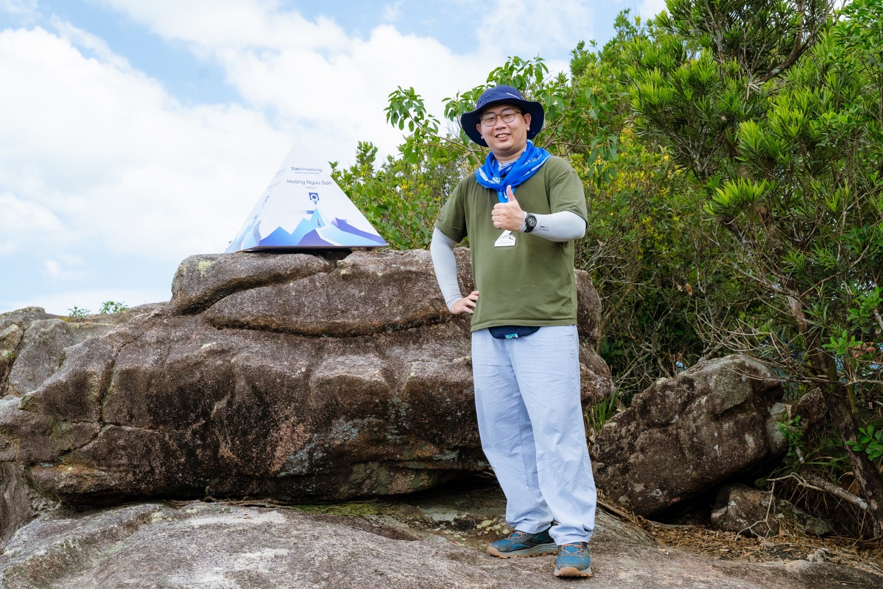 Nguyen Le Phong standing confidently beside the Hoang Nguu Son trekking marker