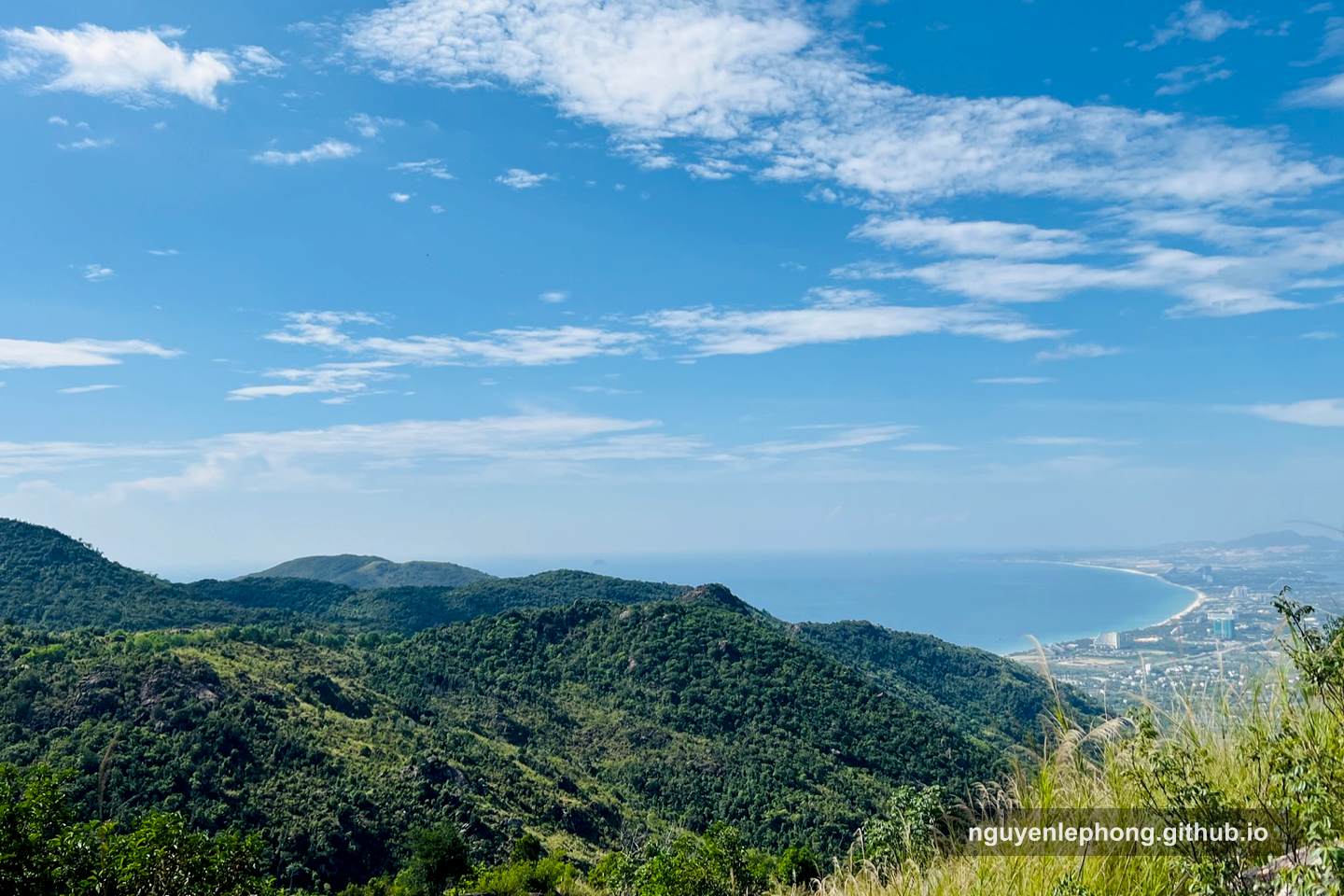 A wide mountain and coastline view opens beneath the trail, giving the team a quiet vantage point to see how far they have come and what comes next.