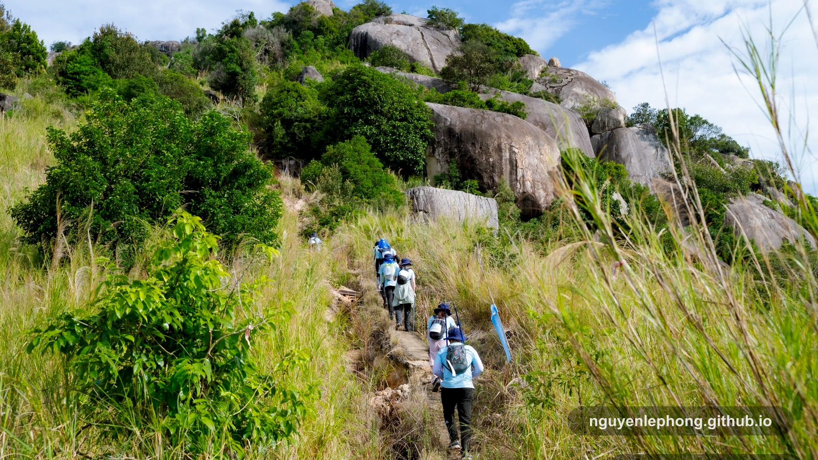 A trail team moves together up a steep slope, a candid reminder that long projects depend on people choosing the same direction before the next climb.