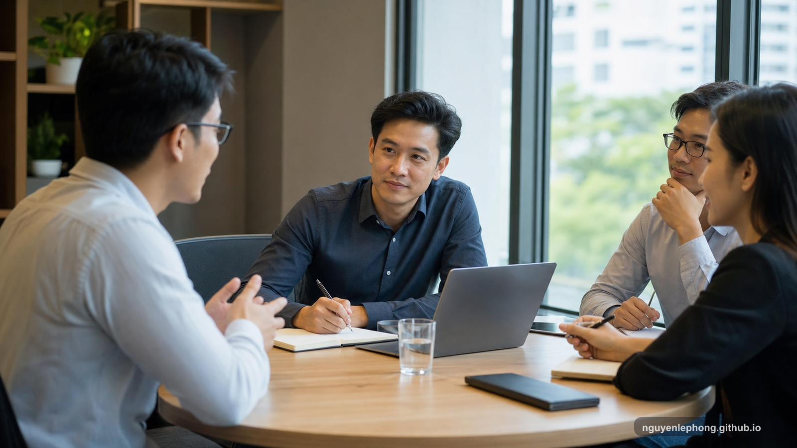 Nguyen Le Phong ngồi ở bàn tròn trong cuộc họp và lắng nghe cẩn thận khi một đồng đội khác đang nói, để căn phòng vẫn mở thay vì kéo sự chú ý về phía mình.