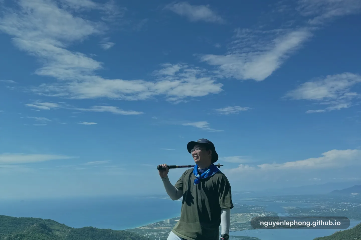 Phong stands on a rocky summit above the coast, carrying only the gear he chose for the climb.