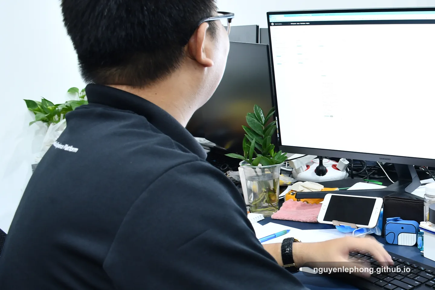 Nguyen Le Phong sits back at a workstation with coffee nearby after the morning check-in, turning the shared discussion into a concrete next move.