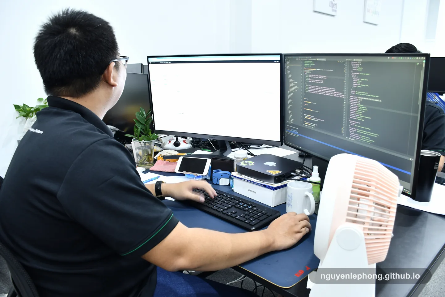 Nguyen Le Phong works through code at a desk with two monitors, tracing one rule in a calm local setup before the wider system needs to join the conversation.