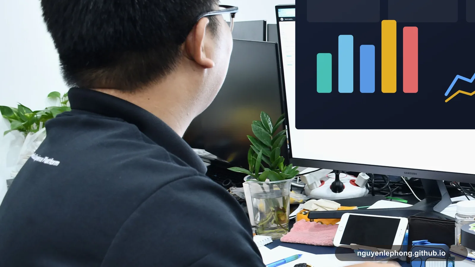 Nguyen Le Phong studies a dashboard and workflow signals at his desk while the screen dominates the decision in front of him.