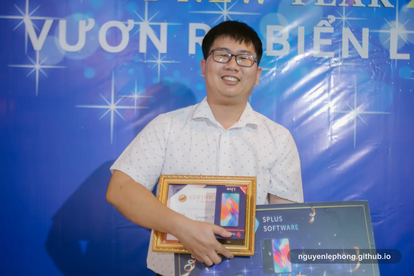 Nguyen Le Phong holds a Best Rookie award at a company recognition event, with the framed certificate and prize board in view.