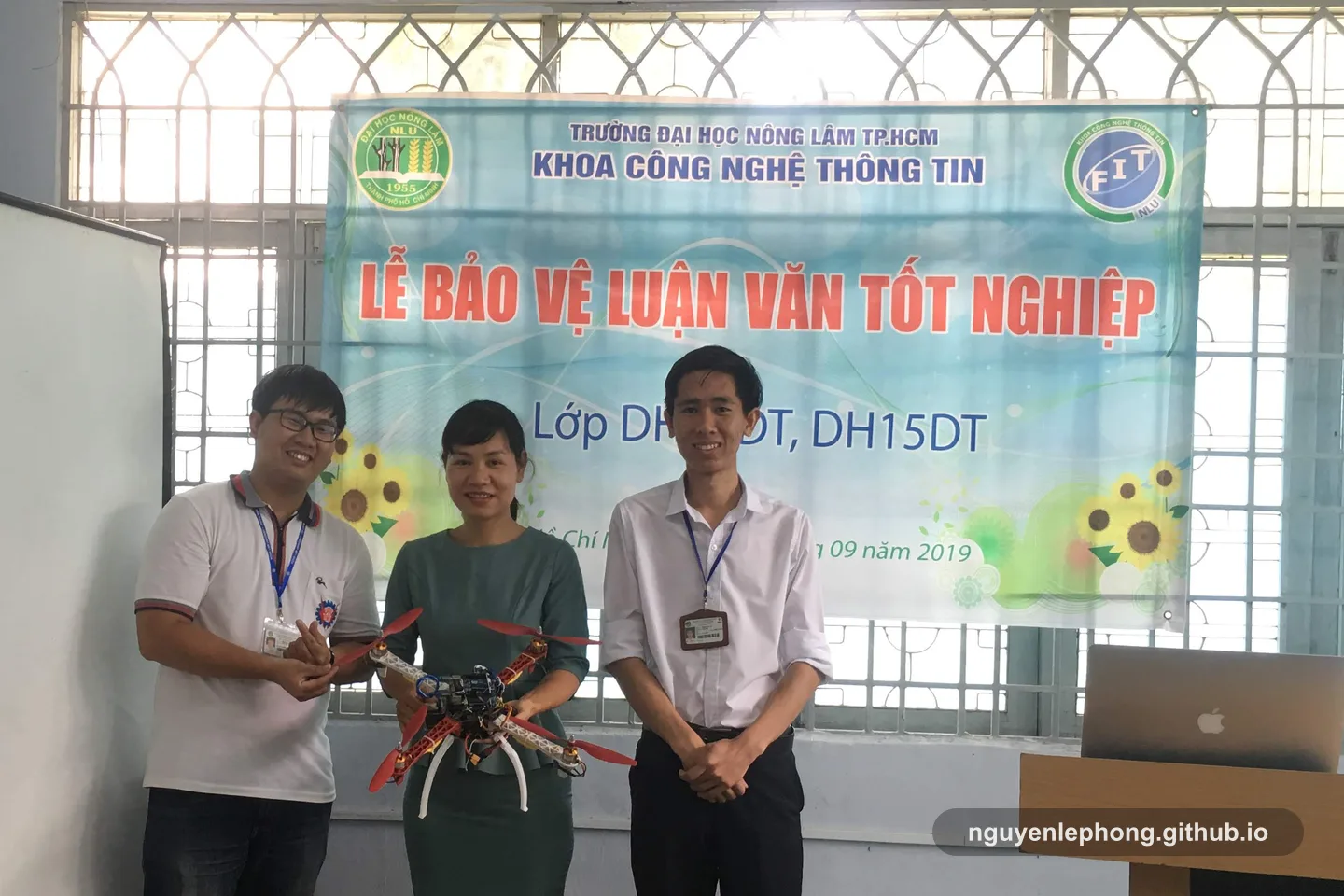 Nguyen Le Phong stands with a teammate and a faculty reviewer beside a drone demo after answering different questions about the same solution.