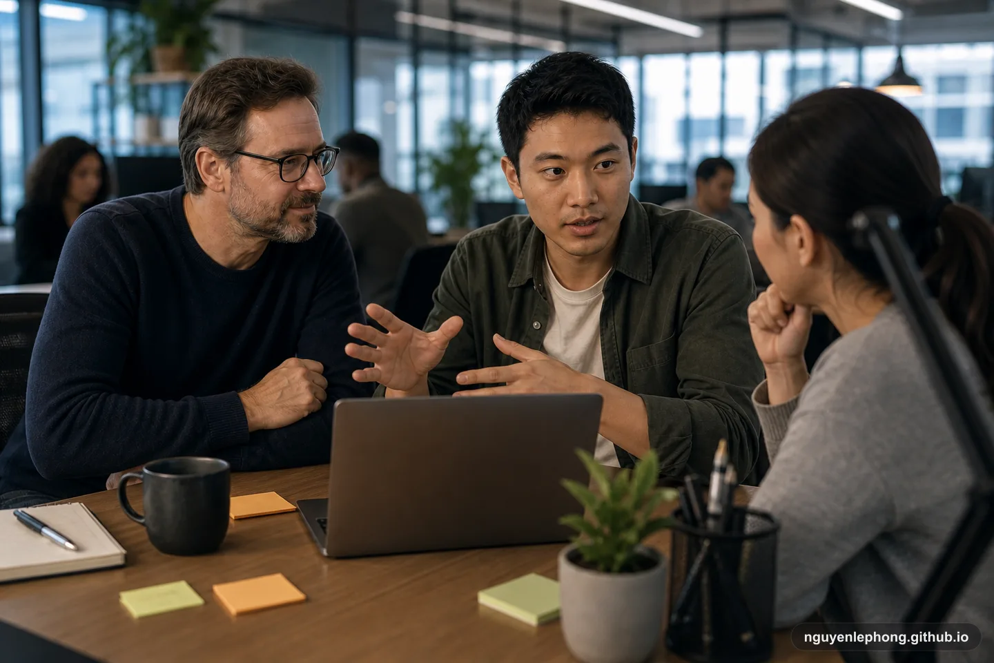 A junior developer explains an implementation trade-off to a teammate while a senior mentor listens nearby with quiet approval.
