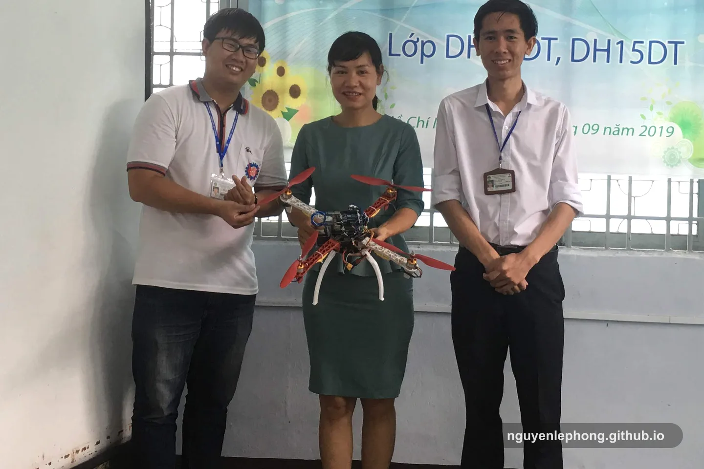 Nguyen Le Phong stands beside a prototype drone with teammates during a project presentation, where a technical claim has to survive a live demonstration.