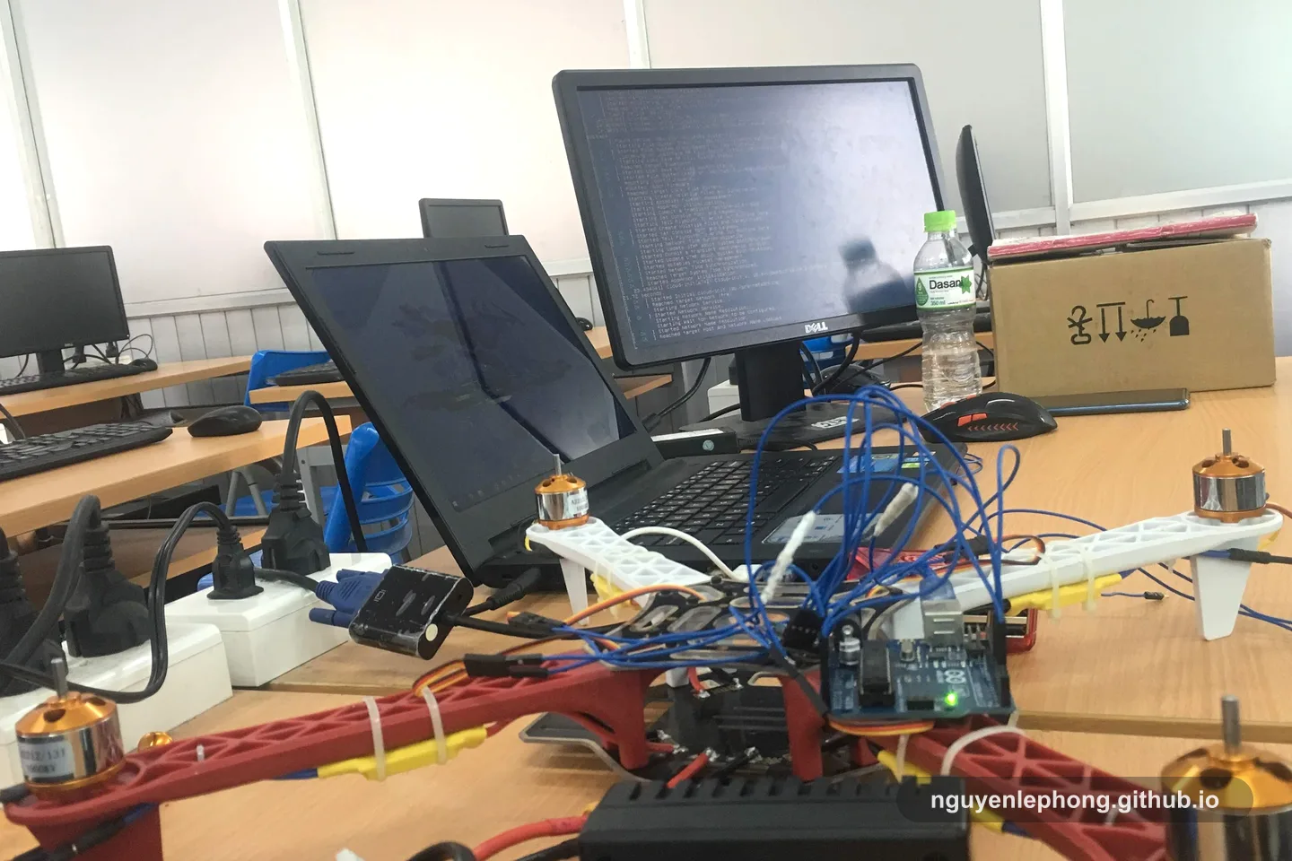 A prototype drone sits on a workbench with cables, a laptop, and test gear before anyone sees the final demonstration.