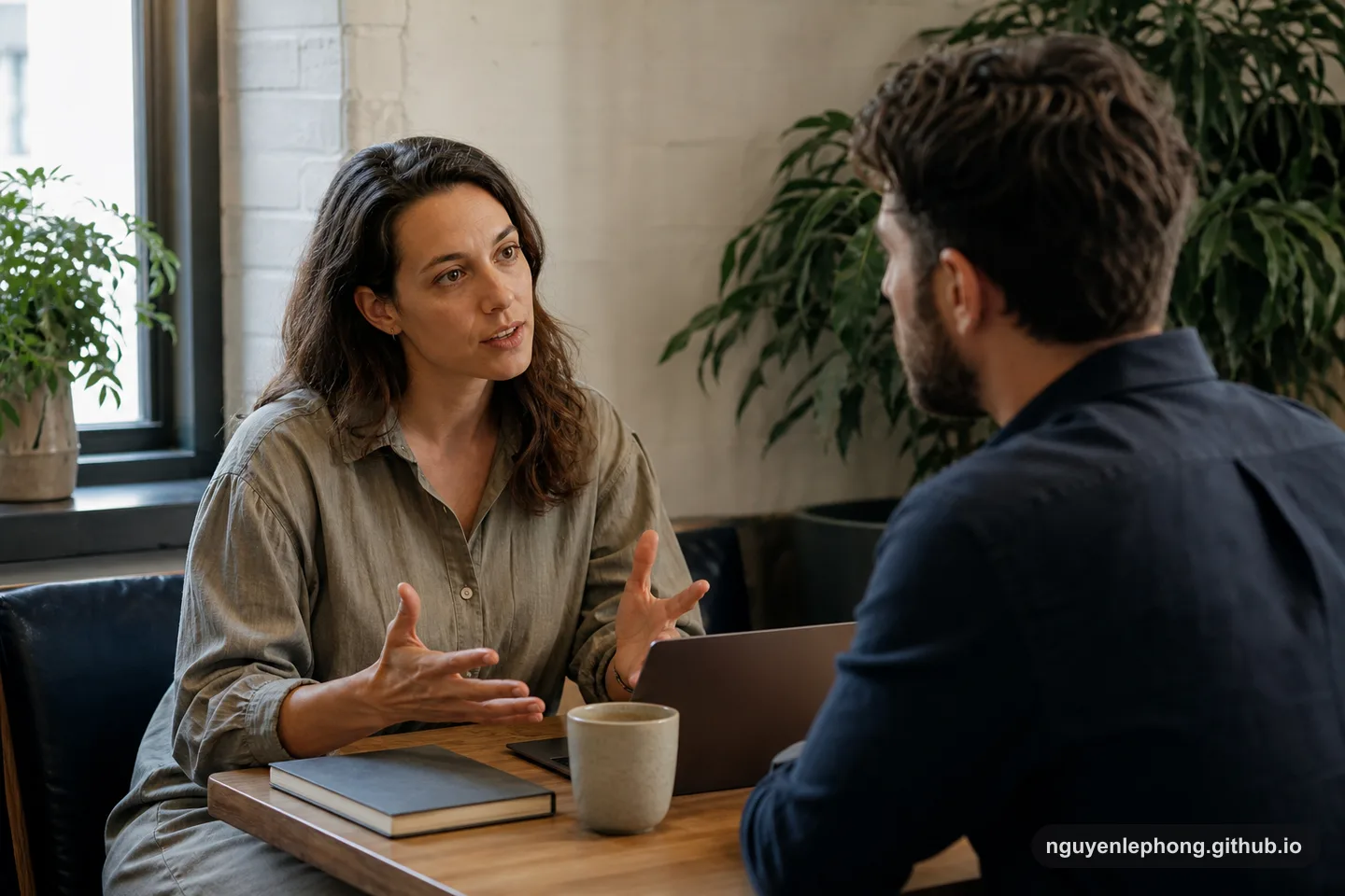 Two colleagues have a calm conversation at a small table, one holding a clear boundary without raising their voice.