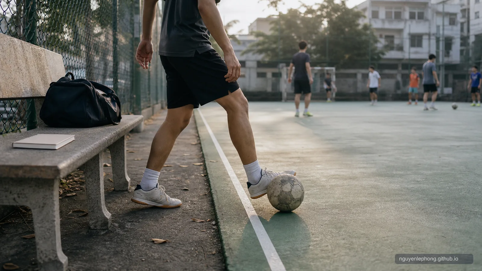 A Vietnamese adult steps from the sideline onto a neighborhood futsal court with a worn ball near the field line.