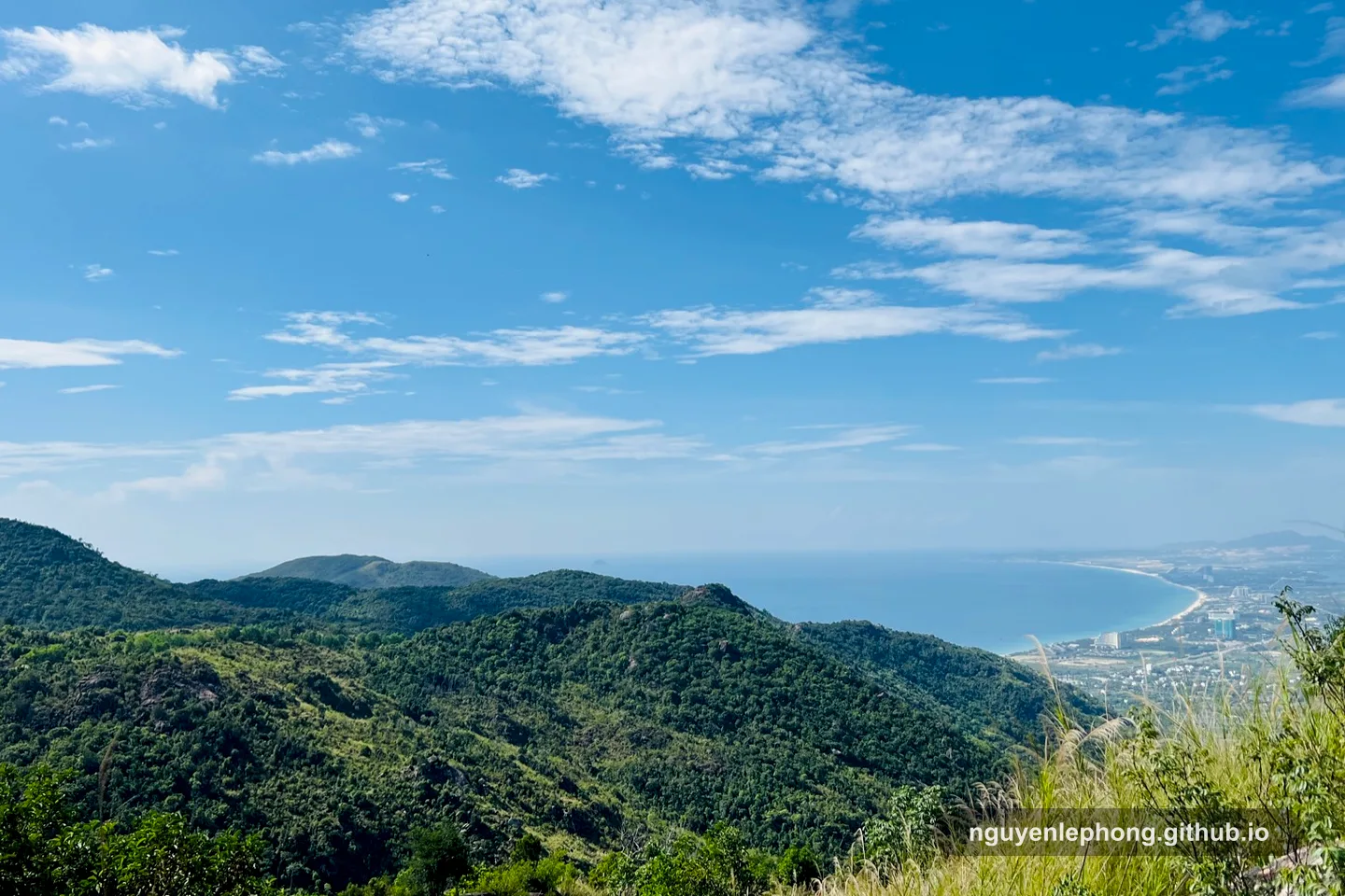 A wide mountain and coastline view opens beneath the trail, giving the team a quiet vantage point to see how far they have come and what comes next.