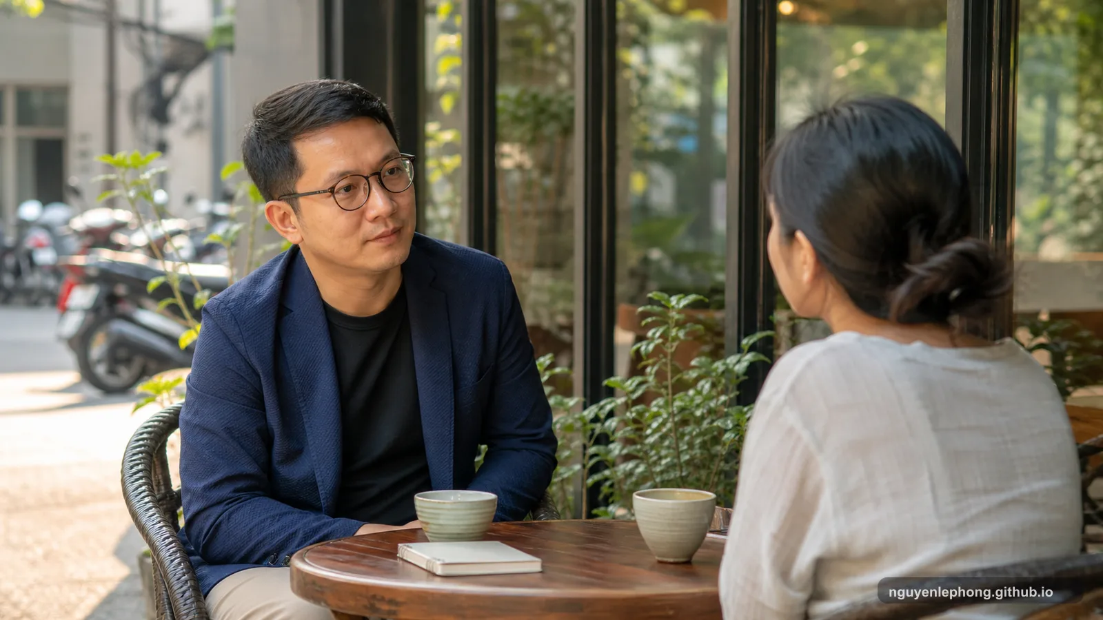Nguyen Le Phong talks quietly with a colleague over coffee, keeping trust warm without pretending it should be blind.